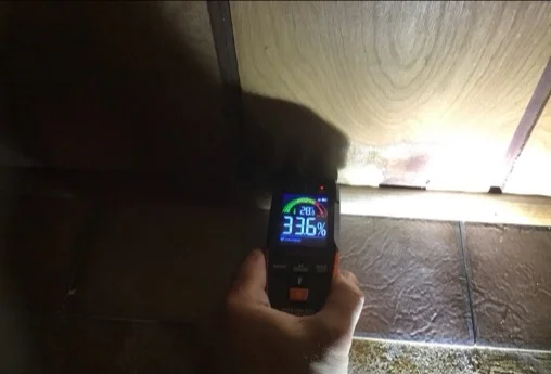Moisture meter reading elevated on basement wall paneling