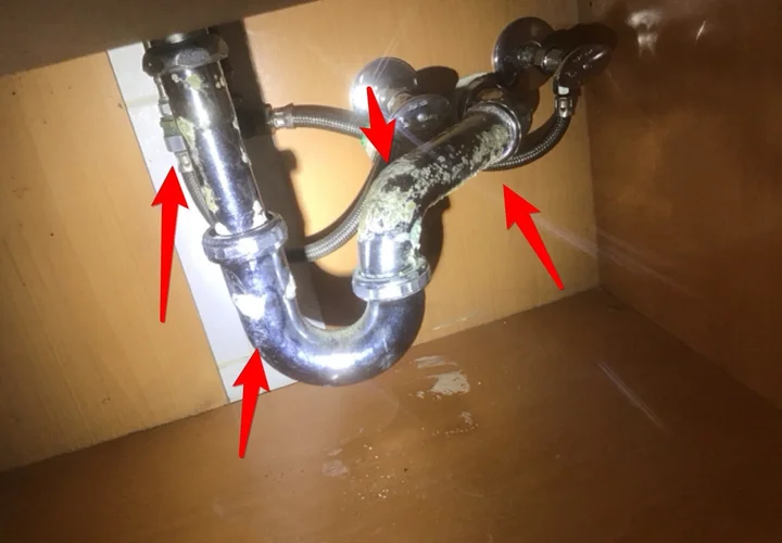 Corroded P-trap drain line under a bathroom sink