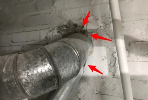 Gaps where the water heater flue enters the chimney in the basement