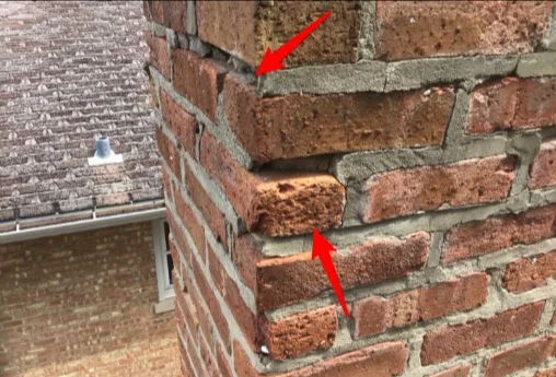 Cracked mortar joints on a brick chimney