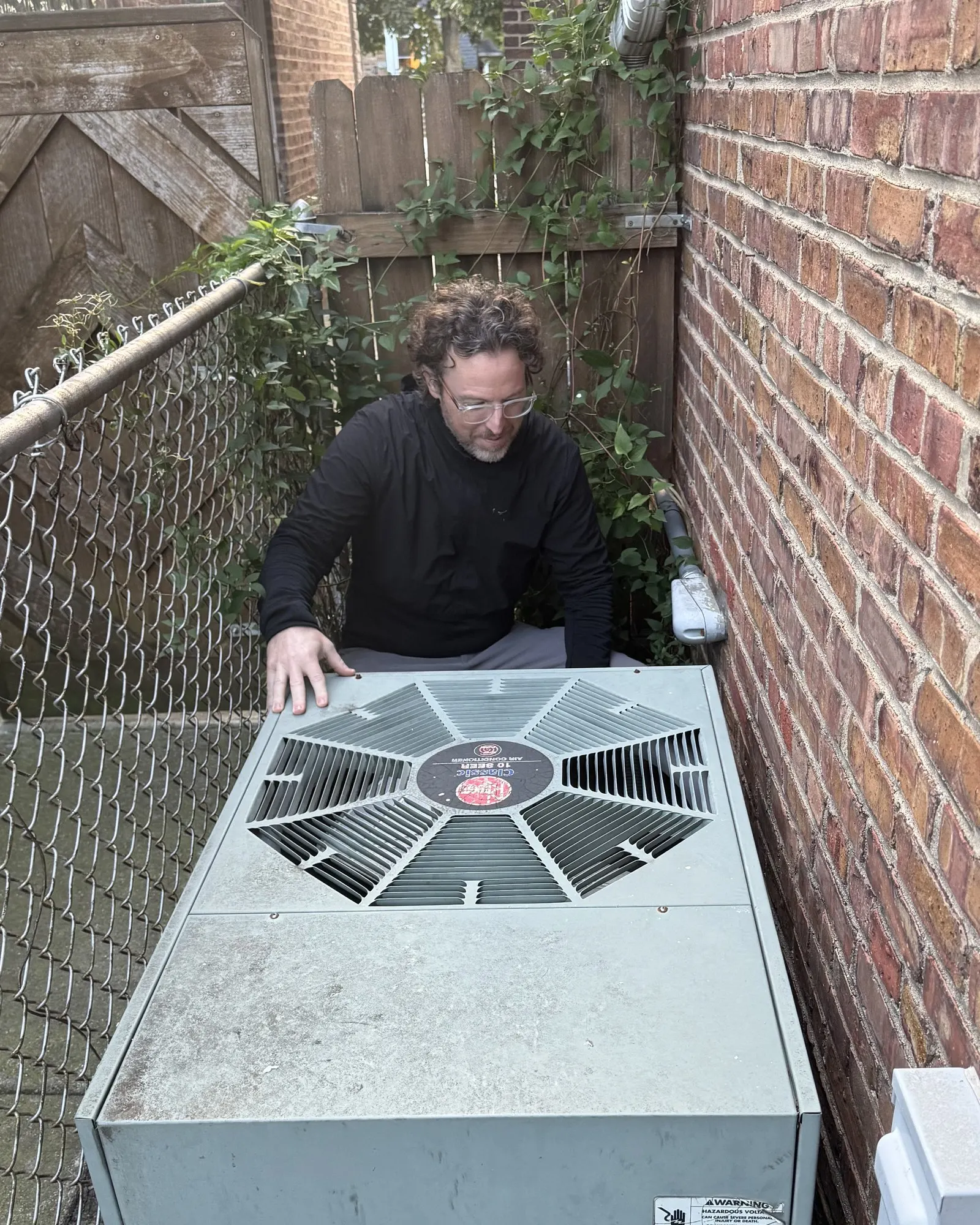 Daniel Murphy, Illinois licensed home inspector, checking an AC condenser on a Chicago inspection