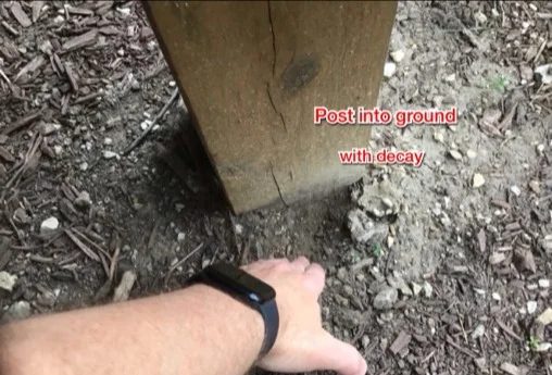 Wood deck posts set directly in soil, with decay at the base (photo 2)