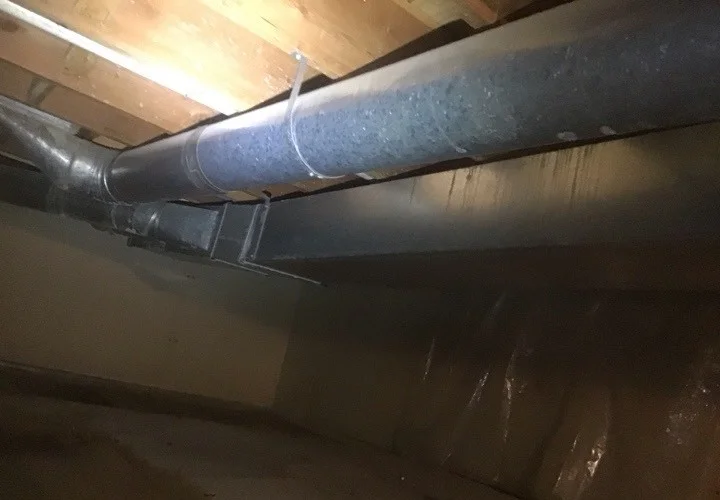 Crawlspace with no insulation between the floor joists and uninsulated HVAC ducts (photo 2)