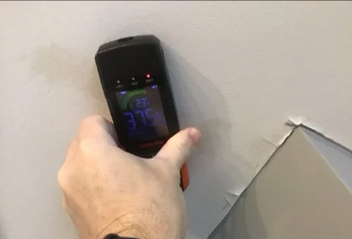 Moisture meter reading elevated at a stained bathroom ceiling (photo 2)