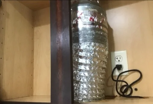 Flexible foil range hood duct in a kitchen cabinet, next to an example of proper smooth metal ducting