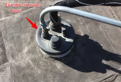 AC refrigerant line penetration sealed with excess sealant, next to an example of a proper boot (photo 2)