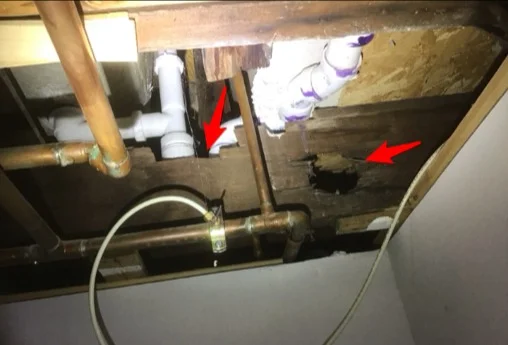 Floor joists notched for plumbing in a basement mechanical room